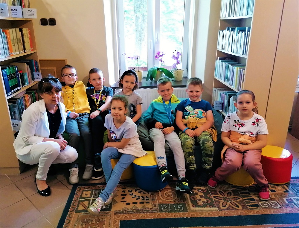 Dzieci słuchają informacji o zasadach pracy biblioteki.