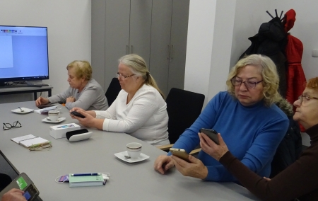 Seniorzy uczą się obsługi smartfona.