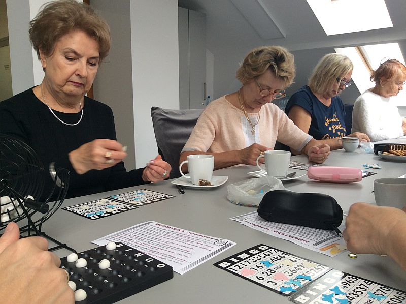 Zdjęcie przedstawia seniorów podczas gdy w bingo.