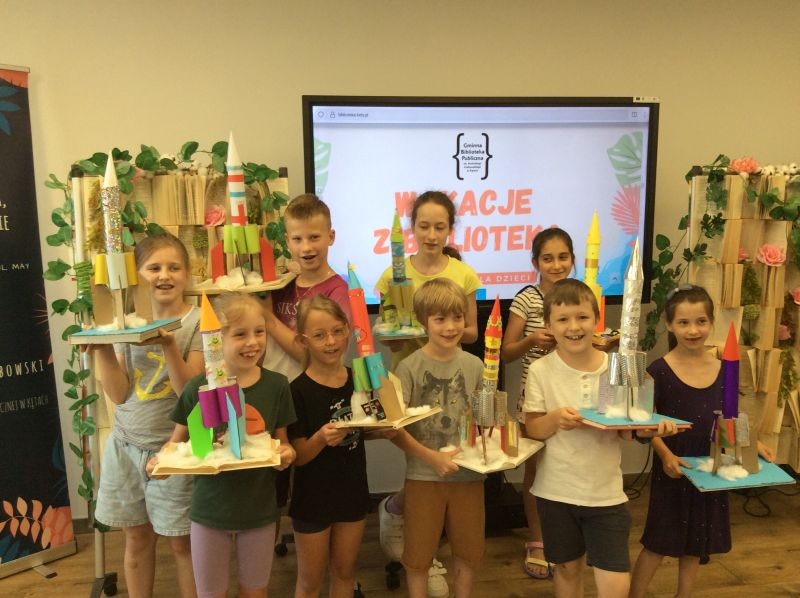Zdjęcie grupowe dzieci wraz z ich kosmicznymi rakietami.