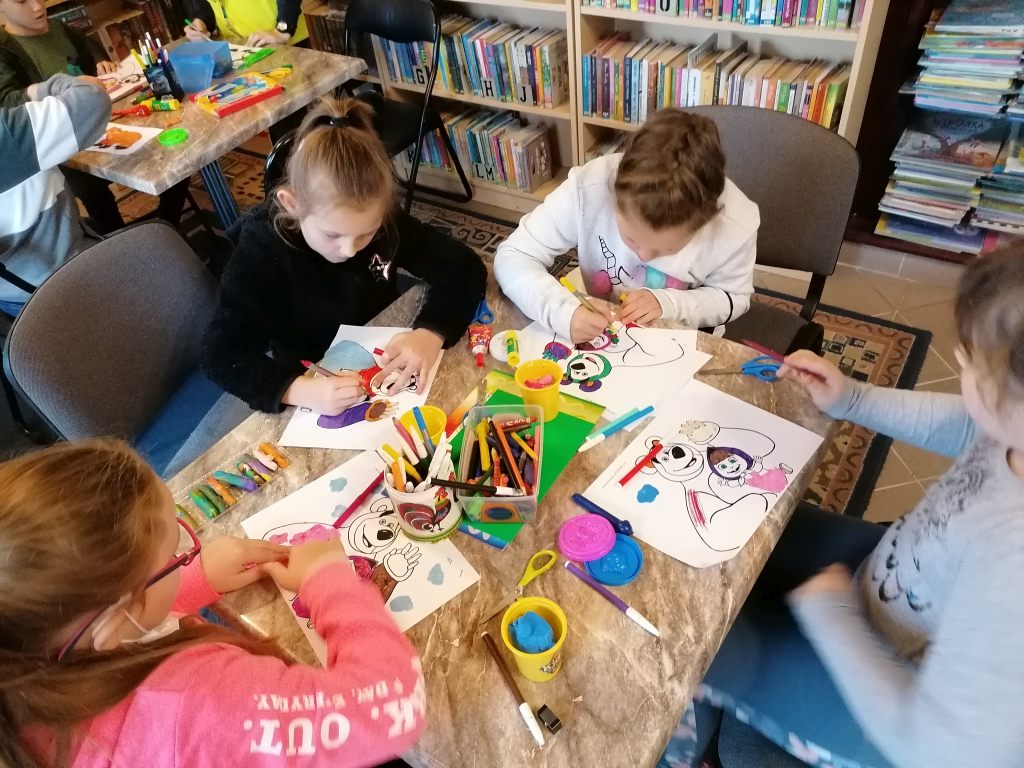 Dzieci tworzą kolaż - plastelna, kredki, papier kolorowy.