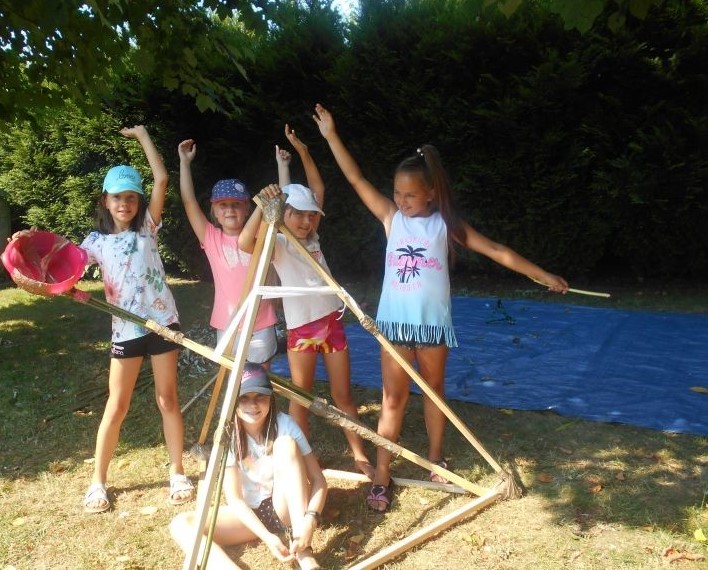 Grupa dziewczyn pozuje przy zbudowanej big katapulcie