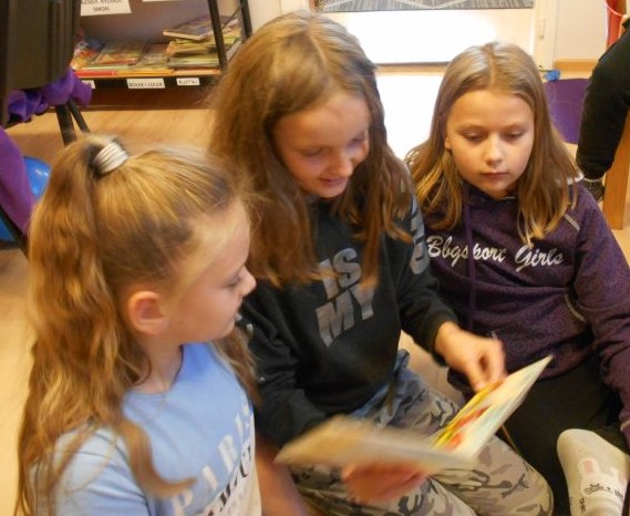 Dziewczynki czytające wiersz Juliana Tuwima