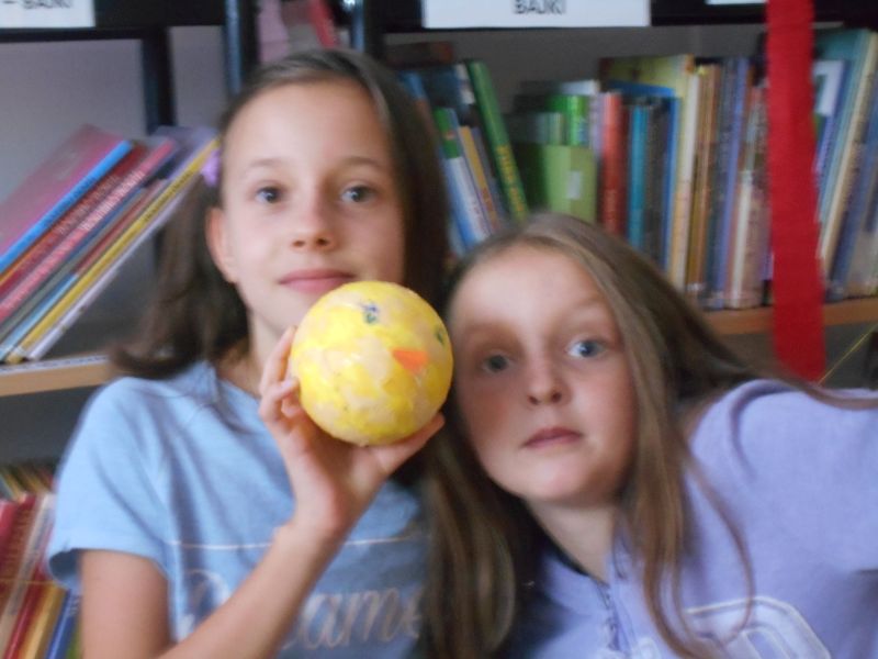 Dwie dziewczynki prezentują Kaczkę Dziwaczkę wykonaną z kuli styropianowej 