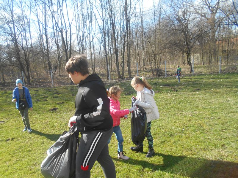 Młodzi sprzątają plac wokół remizy w Łękach