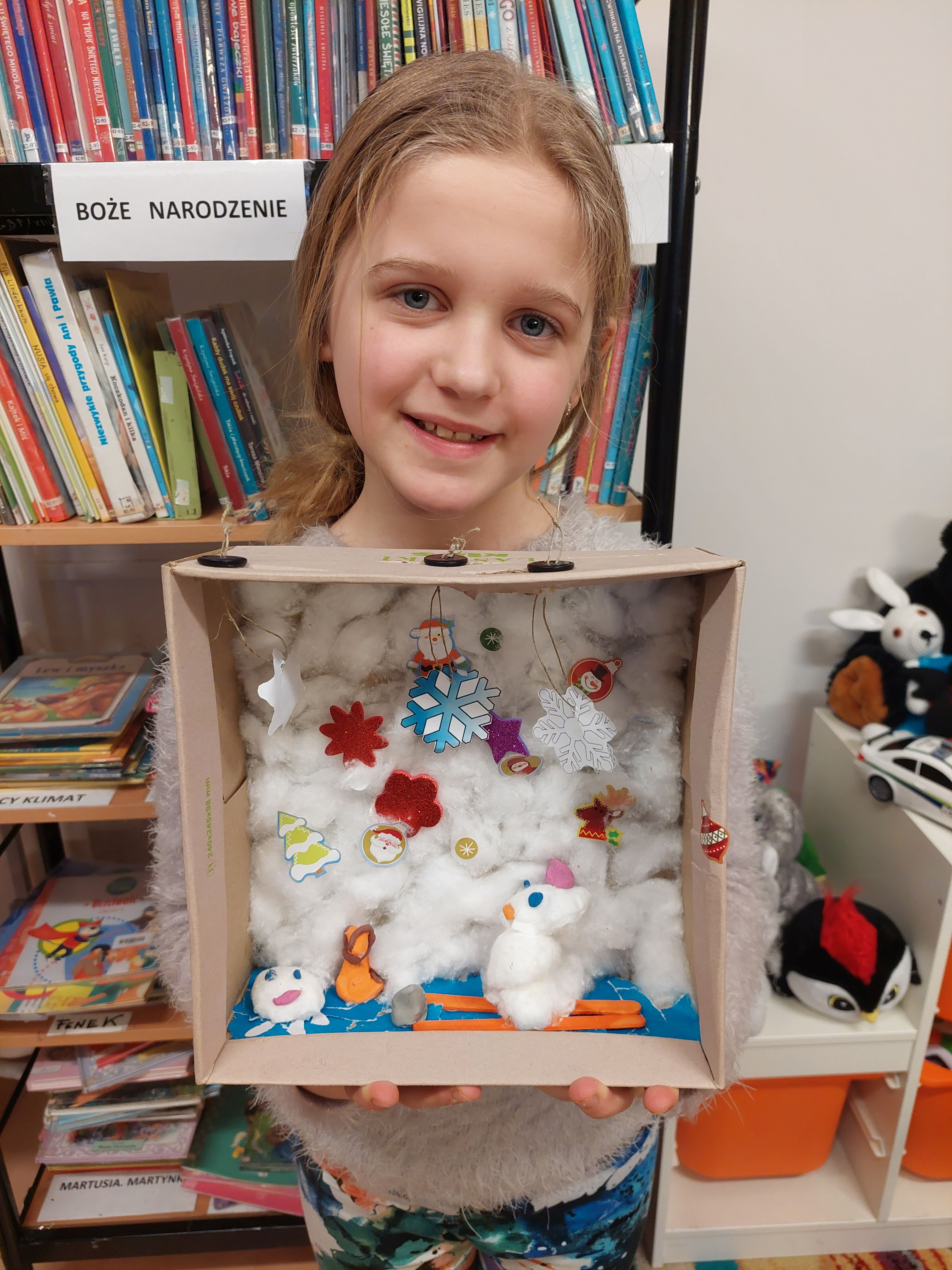 Dziewczynka prezentuje swój zimowy krajobraz w pudełku 