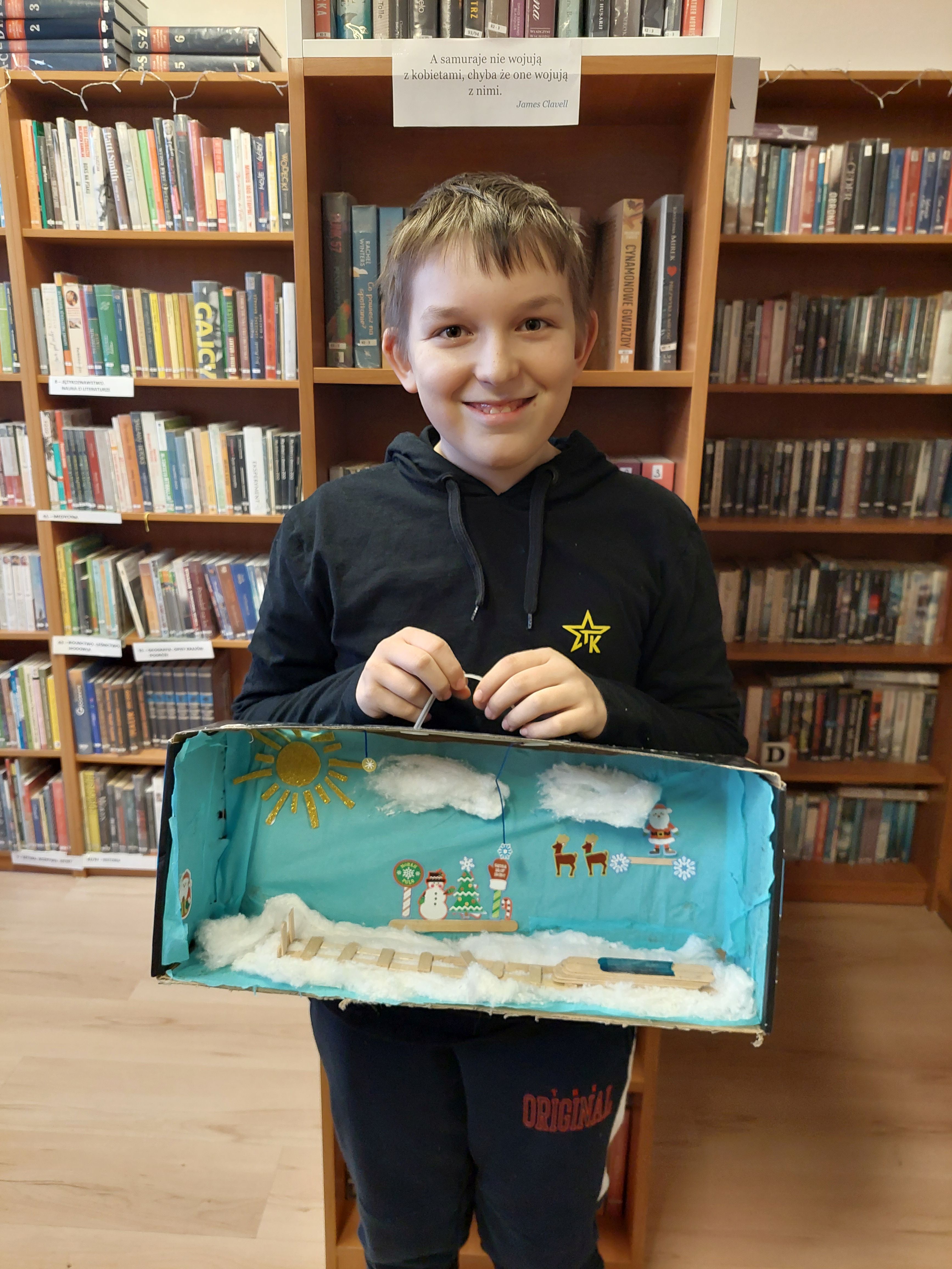 Chłopiec prezentują swój zimowy krajobraz w pudełku